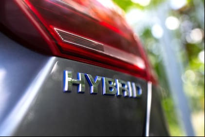 Close-up of Hybrid icon on car body. Environment concept. Ecological transport.