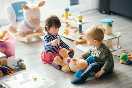 cute little girl and boy playing with toys by the home