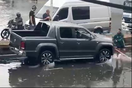 El momento en el que el automovilista embiste contra el vecino que impedía el a una calle inundada