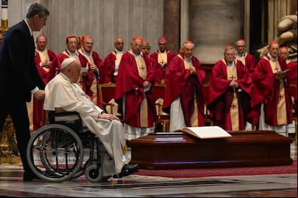 El papa Francisco es empujado en una silla de ruedas hacia el ataúd del cardenal australiano George Pell, durante una misa fúnebre en la basílica de San Pedro en el Vaticano