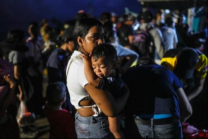 La venezolana Luisleibis Navarro espera con su hijo en brazos para subir a un barco que va desde Miramar, en la costa panameña del Caribe, a la frontera con Colombia, el 25 de febrero de 2025, mientras los migrantes regresan desde el sur de México tras renunciar a llegar a Estados Unidos en un flujo a la inversa provocado por la campaña antiinmigración del gobierno del presidente Donald Trump.
