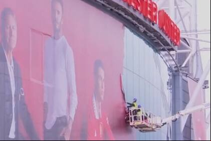 Operarios con una grúa remueven la gigantografía de Cristiano Ronaldo en Old Trafford, el estadio de Manchester United