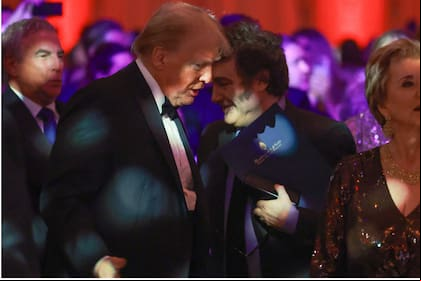 PALM BEACH, FLORIDA - NOVEMBER 14: Argentine President Javier Milei walks past U.S. President-elect Donald Trump as they attend the America First Policy Institute Gala held at Mar-a-Lago on November 14, 2024 in Palm Beach, Florida. The annual event s Grey Team, a nonprofit organization dedicated to preventing military suicide. Joe Raedle/Getty Images/AFP (Photo by JOE RAEDLE / GETTY IMAGES NORTH AMERICA / Getty Images via AFP)