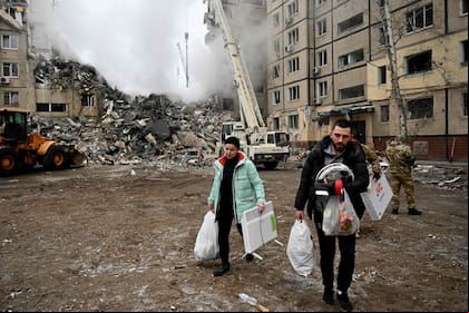 Residentes de una zona residencial de Dnipro rescatan sus enseres tras un ataque ruso