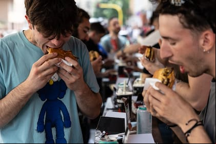 Un grupo de jóvenes come hamburguesas en un restaurante de Milán en 2023.